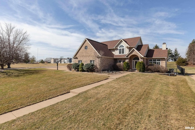 4934 Foxborough Ct, Bettendorf, IA 52722 - traditional-style house featuring a front lawn, a chimney, and brick siding