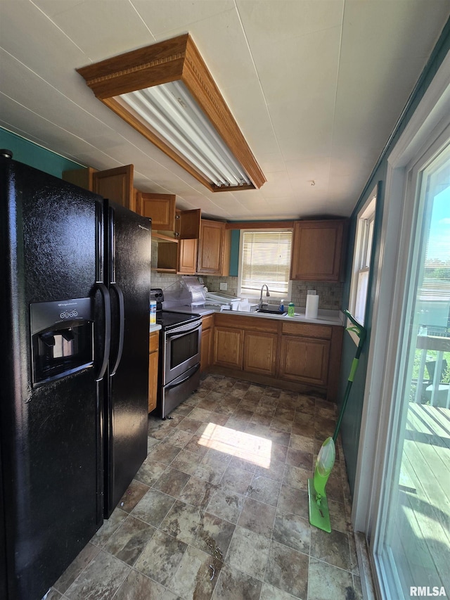 1429 Monroe St, Quincy, IL 62301 - kitchen featuring black refrigerator with ice dispenser, electric range, light countertops, decorative backsplash, and brown cabinets