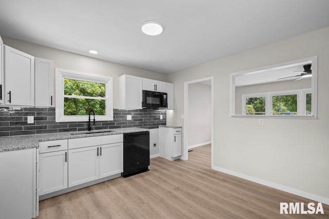 3040 Oak Street Ct, Bettendorf, IA 52722 - kitchen with black appliances, healthy amount of natural light, and white cabinets