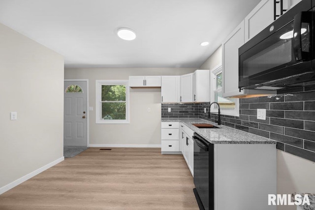 3040 Oak Street Ct, Bettendorf, IA 52722 - kitchen with black appliances, white cabinetry, light stone countertops, healthy amount of natural light, and recessed lighting