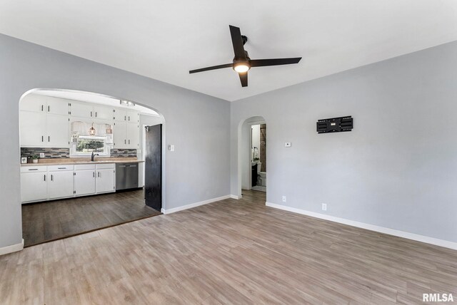 115 4th St, Colona, IL 61241 - unfurnished living room featuring ceiling fan, light wood-style floors, and arched walkways