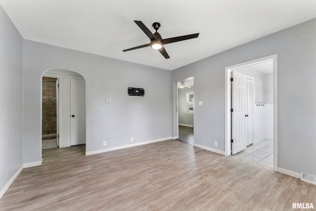 115 4th St, Colona, IL 61241 - unfurnished room featuring ceiling fan, arched walkways, and light wood-type flooring
