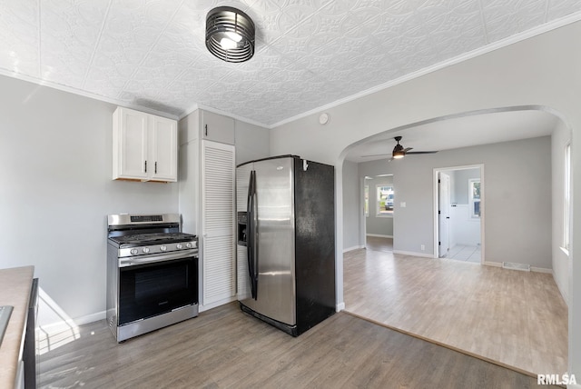 115 4th St, Colona, IL 61241 - kitchen with stainless steel appliances, arched walkways, a ceiling fan, light wood finished floors, and an ornate ceiling