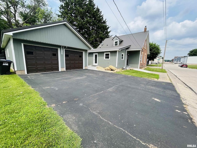 406S 3rd St, Bellevue, IA 52031 - view of front of property with a chimney, an outdoor structure, a garage, and a metal roof