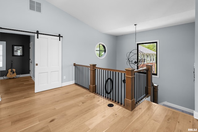 223 N 2nd St, Le Claire, IA 52753 - hallway with an upstairs landing, light wood-style floors, healthy amount of natural light, and a barn door