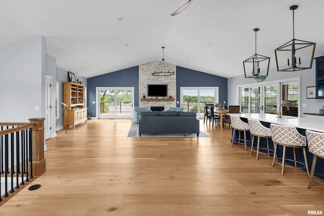 223 N 2nd St, Le Claire, IA 52753 - living room with light wood finished floors, vaulted ceiling, healthy amount of natural light, and a fireplace