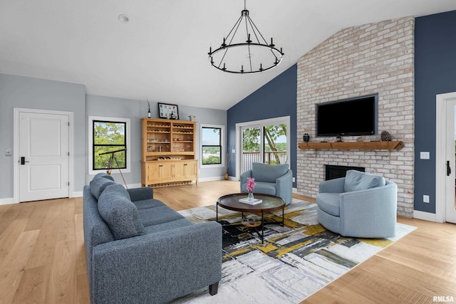 223 N 2nd St, Le Claire, IA 52753 - living room with wood finished floors, lofted ceiling, a chandelier, and a fireplace