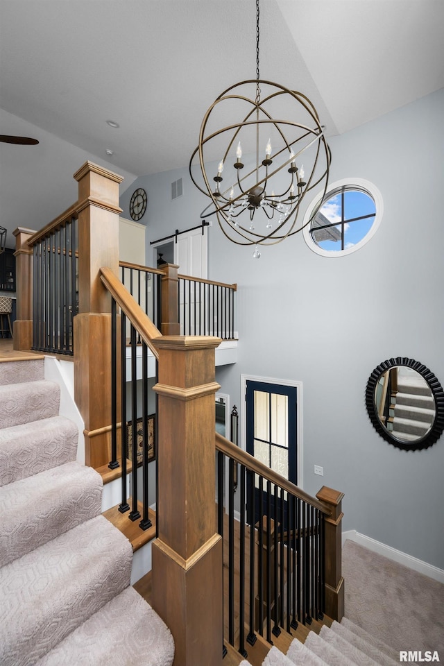 223 N 2nd St, Le Claire, IA 52753 - staircase featuring a chandelier, a high ceiling, and carpet floors