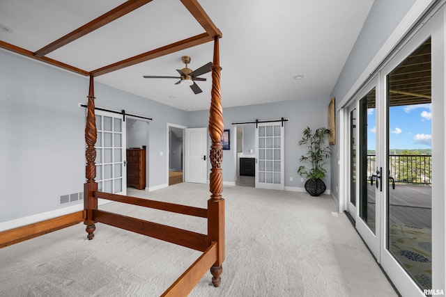 223 N 2nd St, Le Claire, IA 52753 - bedroom with a barn door, access to exterior, light colored carpet, and french doors