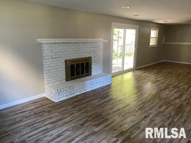 2616 W 56th St, Davenport, IA 52806 - unfurnished living room featuring dark wood-type flooring and a brick fireplace