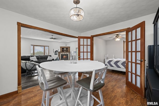 406 234th St, Aledo, IL 61231 - dining area with french doors, a ceiling fan, a fireplace, wood finished floors, and a chandelier