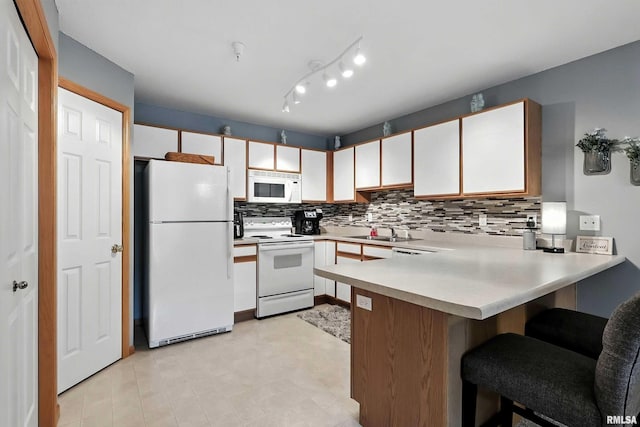 109 E Price St Unit 203, Eldridge, IA 52748 - kitchen featuring white appliances, a peninsula, light countertops, decorative backsplash, and white cabinets