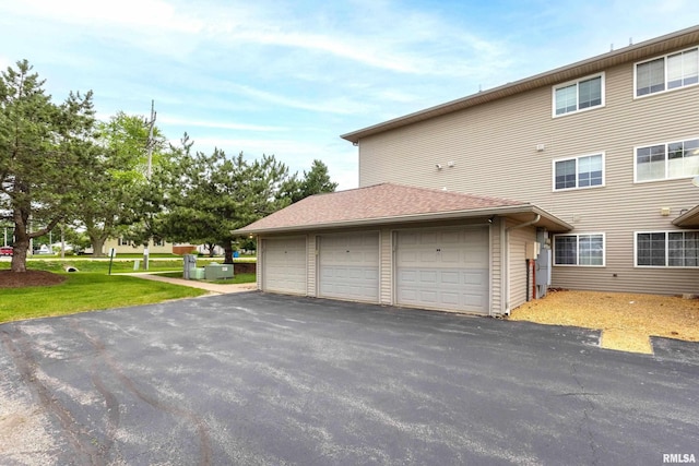 109 E Price St Unit 203, Eldridge, IA 52748 - view of property exterior with a lawn, a garage, and a shingled roof