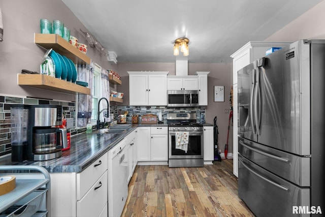 2207 4th St Unit A, East Moline, IL 61244 - kitchen featuring appliances with stainless steel finishes, open shelves, dark countertops, and decorative backsplash
