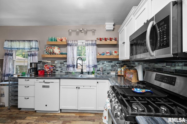 2207 4th St Unit A, East Moline, IL 61244 - kitchen featuring appliances with stainless steel finishes, open shelves, healthy amount of natural light, and backsplash