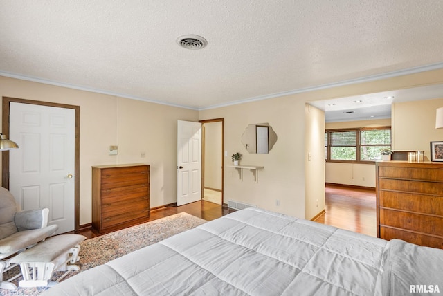 17 Wildwood Trl, Bettendorf, IA 52722 - bedroom with wood finished floors, ornamental molding, and a textured ceiling