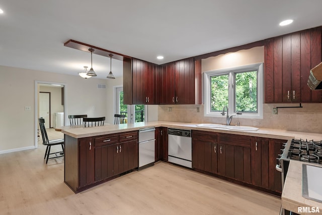 17 Wildwood Trl, Bettendorf, IA 52722 - kitchen with dishwasher, light wood-style flooring, a peninsula, light countertops, and decorative backsplash