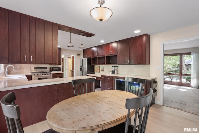17 Wildwood Trl, Bettendorf, IA 52722 - kitchen with appliances with stainless steel finishes, decorative backsplash, light wood-style flooring, light countertops, and recessed lighting