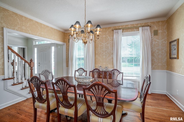 2806 E 42nd Ct, Davenport, IA 52807 - dining room featuring a chandelier, wallpapered walls, light wood-style floors, a textured ceiling, and crown molding