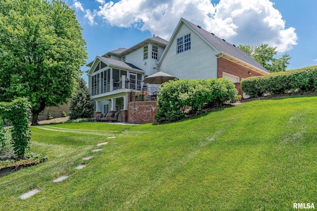 2806 E 42nd Ct, Davenport, IA 52807 - back of property featuring a sunroom, brick siding, a lawn, and a patio