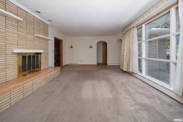 1635 Eastmere Dr, Davenport, IA 52803 - unfurnished living room with carpet flooring, a brick fireplace, arched walkways, and a baseboard radiator