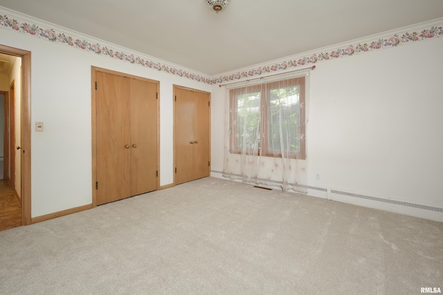 1635 Eastmere Dr, Davenport, IA 52803 - unfurnished bedroom with two closets, light colored carpet, and ornamental molding