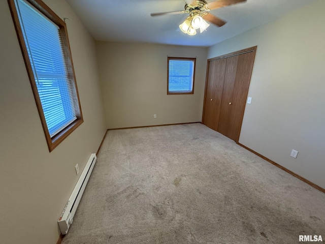 503 Lafayette St, Lafayette, IL 61449 - unfurnished bedroom featuring baseboard heating, carpet flooring, a closet, and ceiling fan