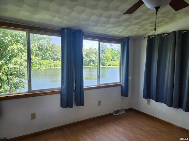 32 Crescent Lk, Alpha, IL 61413 - empty room featuring healthy amount of natural light, a water view, and wood finished floors