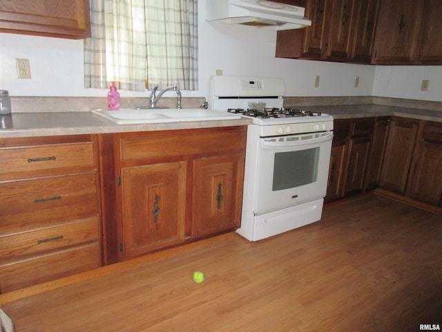 32 Crescent Lk, Alpha, IL 61413 - kitchen featuring white gas stove, custom range hood, brown cabinets, light countertops, and light wood-type flooring