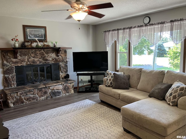 420 E Garfield St, Kewanee, IL 61443 - living room with a ceiling fan, a textured ceiling, wood finished floors, and a stone fireplace