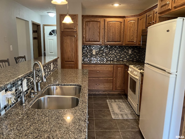 420 E Garfield St, Kewanee, IL 61443 - kitchen with white appliances, backsplash, dark tile patterned floors, and brown cabinetry