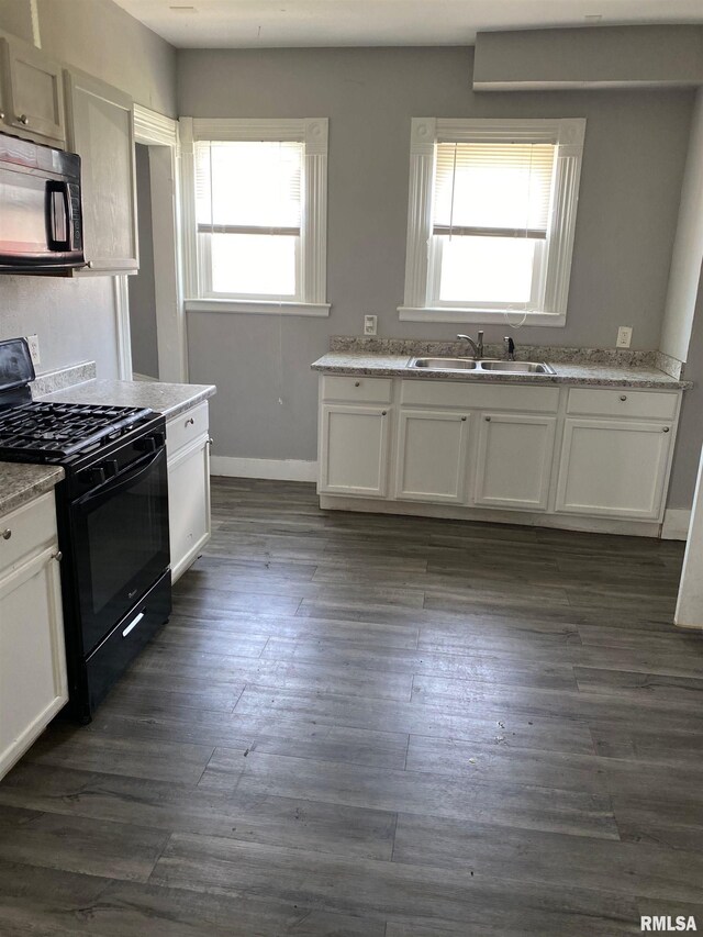 1923 Pershing Ave, Davenport, IA 52803 - kitchen with black appliances, white cabinets, and dark wood finished floors