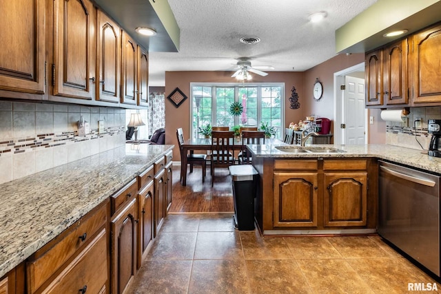 1814 Testa Dr, Marion, IL 62959 - kitchen with dishwasher, a peninsula, a ceiling fan, brown cabinets, and a textured ceiling