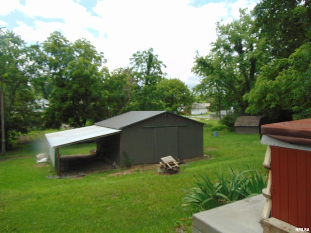 1306 Newton Ave, Johnston City, IL 62959 - view of grassy yard with a carport and an outbuilding