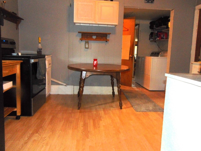1306 Newton Ave, Johnston City, IL 62959 - kitchen featuring stainless steel range with electric cooktop, washing machine and dryer, and light wood-style floors
