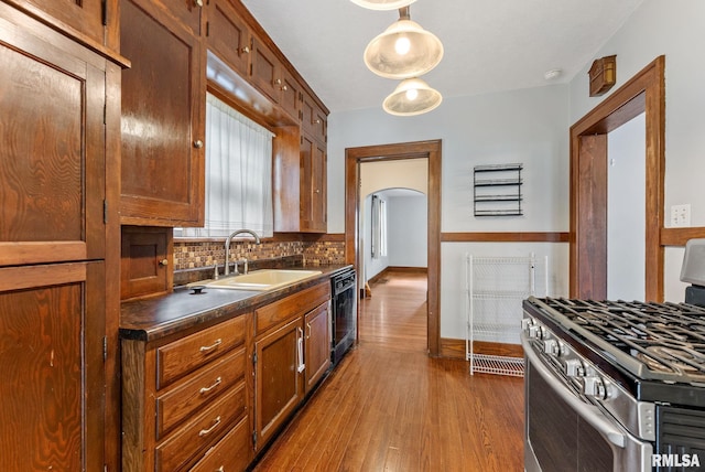 921 45th St, Rock Island, IL 61201 - kitchen featuring gas stove, dark countertops, decorative backsplash, dark wood-style flooring, and dishwasher