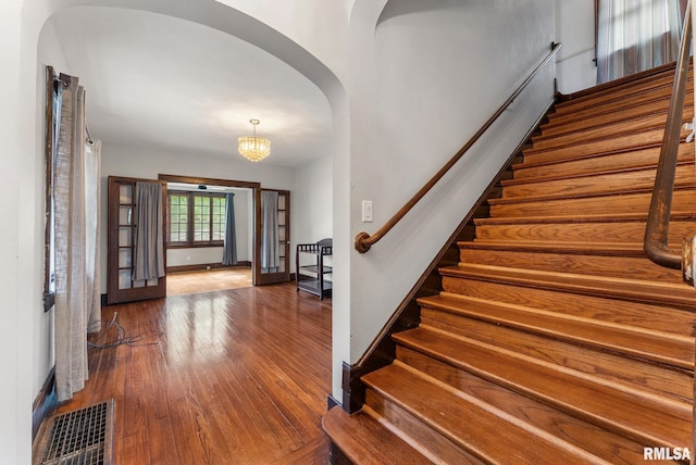 921 45th St, Rock Island, IL 61201 - entrance foyer with arched walkways, wood-type flooring, stairs, and a chandelier