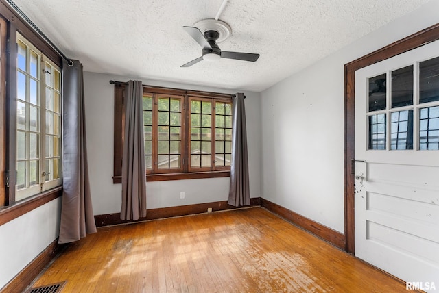 921 45th St, Rock Island, IL 61201 - empty room with light wood-style floors, a textured ceiling, a ceiling fan, and plenty of natural light