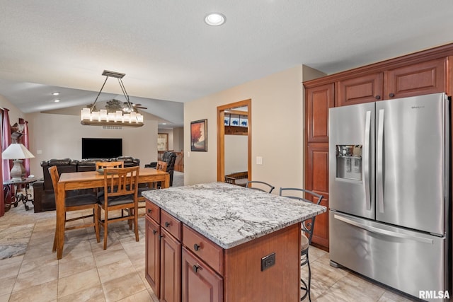 10984 150th St, Davenport, IA 52804 - kitchen with stainless steel fridge with ice dispenser, a kitchen bar, a center island, open floor plan, and light stone counters