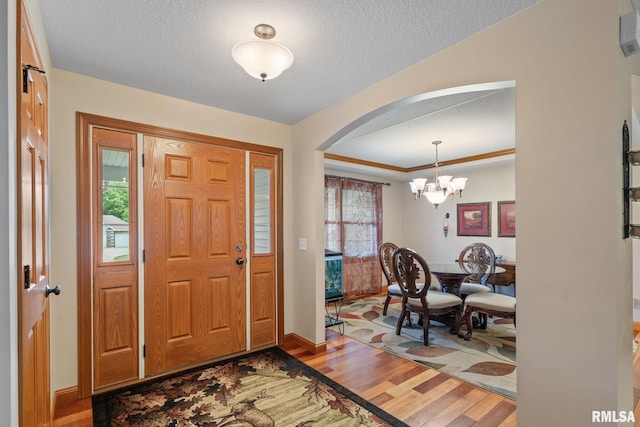 10984 150th St, Davenport, IA 52804 - entryway with arched walkways, wood finished floors, a textured ceiling, and a chandelier