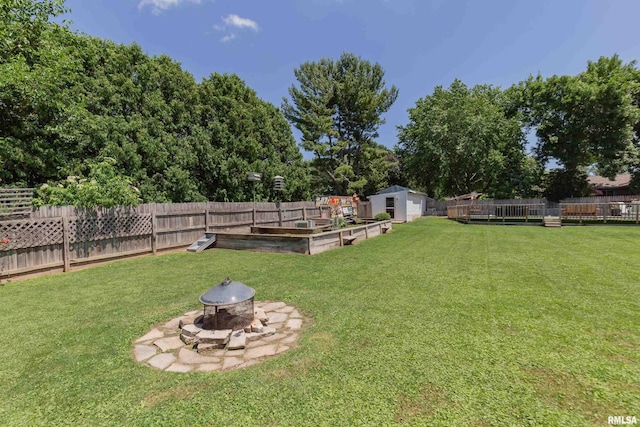 1924 E Rusholme St, Davenport, IA 52806 - fenced backyard featuring a fire pit, a storage unit, a garden, and view of wooded area