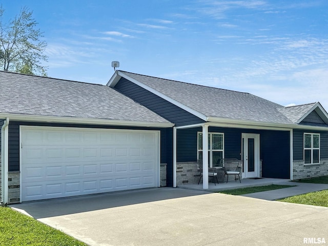 1612 N Garfield St, Marion, IL 62959 - ranch-style home with concrete driveway, stone siding, a shingled roof, a garage, and a porch