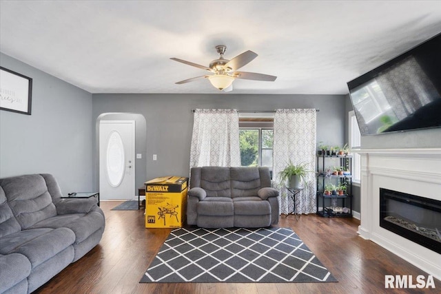 2506 N Howell St, Davenport, IA 52804 - living room with arched walkways, a glass covered fireplace, wood finished floors, and a ceiling fan