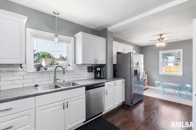 2506 N Howell St, Davenport, IA 52804 - kitchen with stainless steel appliances, dark wood-style flooring, tasteful backsplash, and white cabinetry