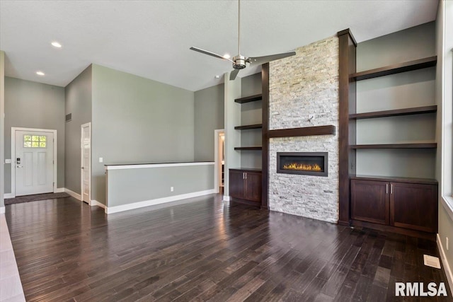 6691 Spring Creek Dr, Bettendorf, IA 52722 - unfurnished living room with a stone fireplace, wood finished floors, built in shelves, ceiling fan, and recessed lighting
