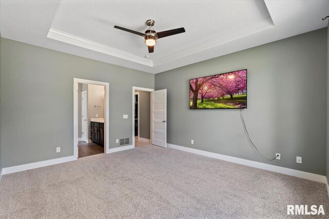 6691 Spring Creek Dr, Bettendorf, IA 52722 - unfurnished bedroom with a tray ceiling, carpet floors, ensuite bath, crown molding, and a textured ceiling