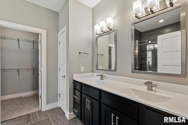 6691 Spring Creek Dr, Bettendorf, IA 52722 - full bathroom featuring double vanity, a stall shower, and a spacious closet