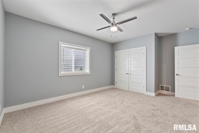 6691 Spring Creek Dr, Bettendorf, IA 52722 - unfurnished bedroom featuring carpet floors, a closet, a textured ceiling, and ceiling fan