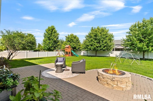 6691 Spring Creek Dr, Bettendorf, IA 52722 - fenced backyard featuring a fire pit, a patio, and a playground