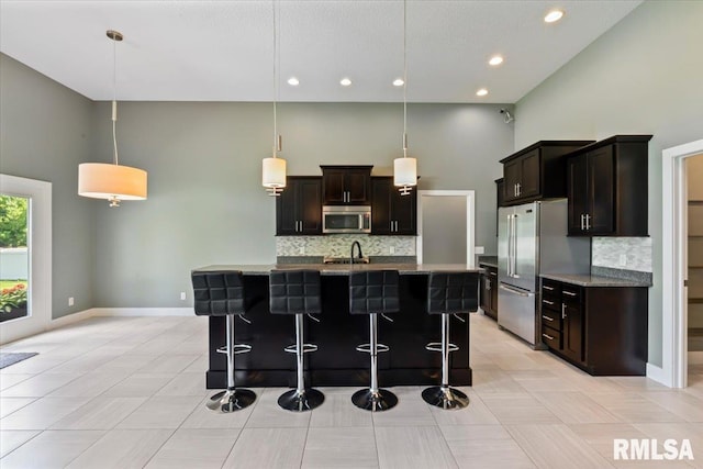 6691 Spring Creek Dr, Bettendorf, IA 52722 - kitchen with stainless steel appliances, a high ceiling, decorative backsplash, a breakfast bar, and stone counters